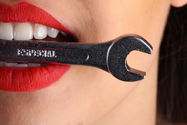 close-view-of-woman-with-red-lips-biting-gray-special-wrench-1161929